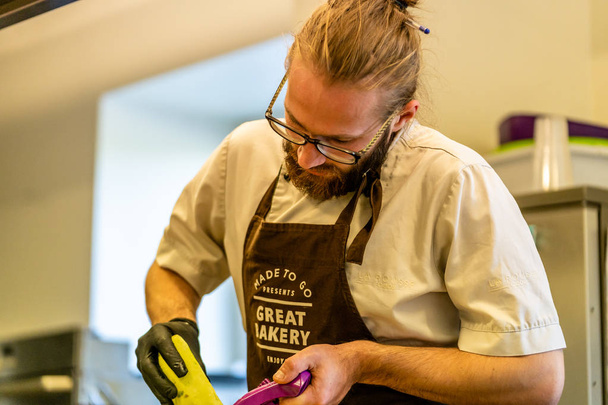 Male Chef Cutting Eggplant in the Kitchen - with Glove on his Hand - Photo, Image