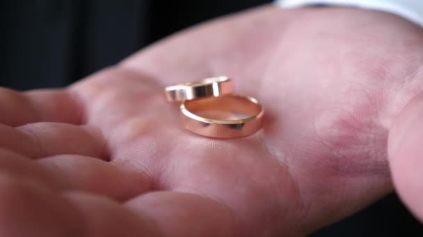 Snubní prsteny leží na dlaň ženicha, detail - Záběry, video