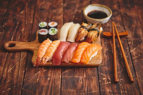 Sushi Set. Different kinds of sushi rolls on wooden serving board - Fotoğraf, Görsel