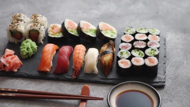 Composition of different kinds of sushi rolls placed on black stone board - Footage, Video