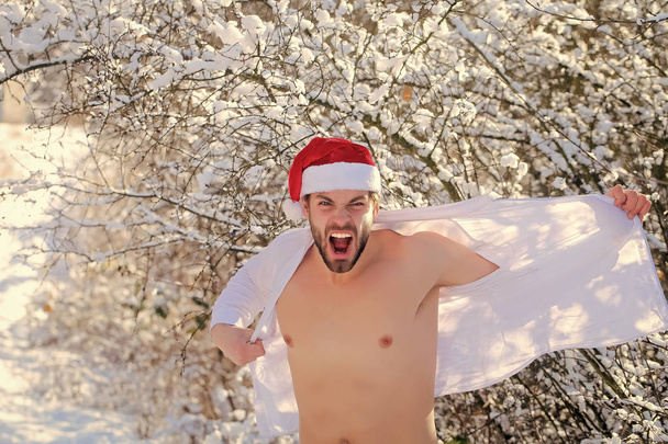 Angry man undressing shirt on winter day - Foto, afbeelding