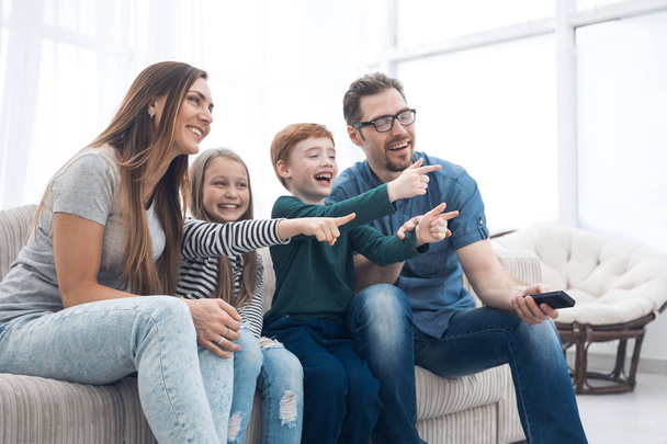 happy family sitting watching TV in their home - Zdjęcie, obraz