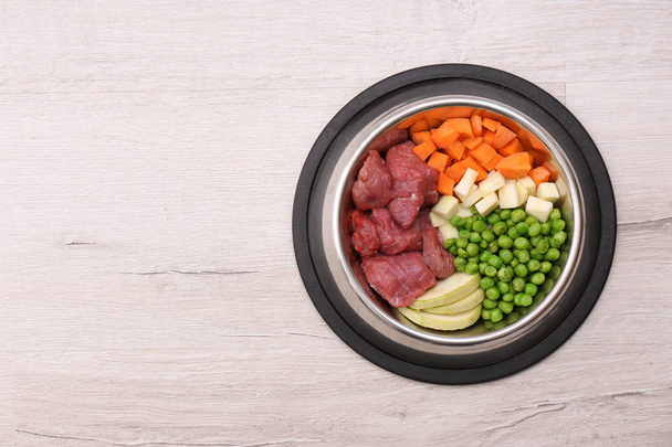 Ciotola con cibo organico per cani su sfondo chiaro, vista dall'alto. Spazio per testo
 - Foto, immagini