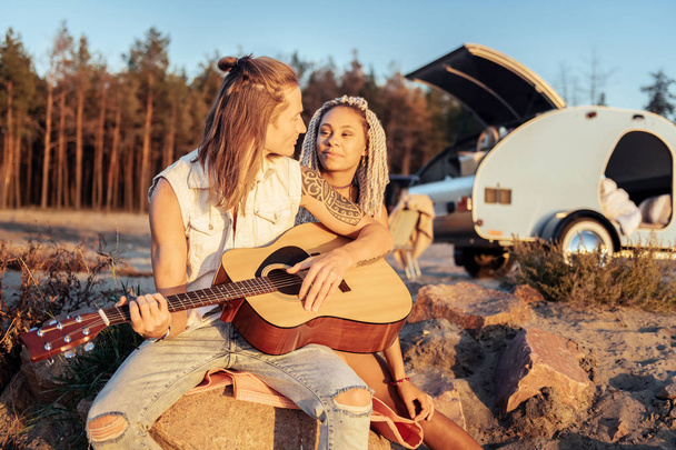 Loving boyfriend singing song for his appealing woman with dreadlocks - 写真・画像