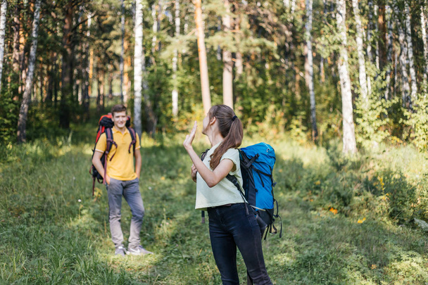couple of tourists with backpacks hiking in a forest - Valokuva, kuva