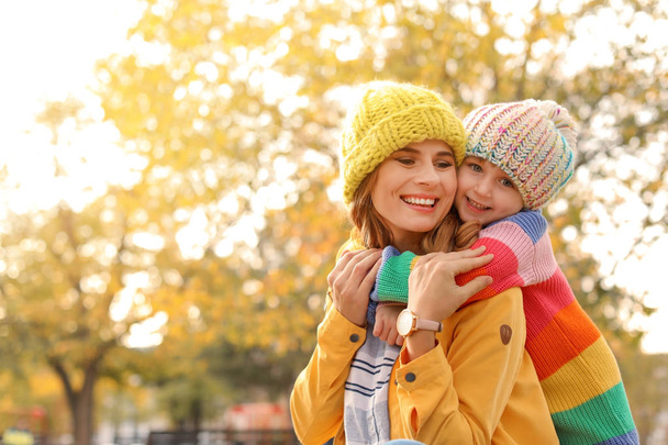 Mother with her cute daughter spending time together in park. Autumn walk - Foto, imagen
