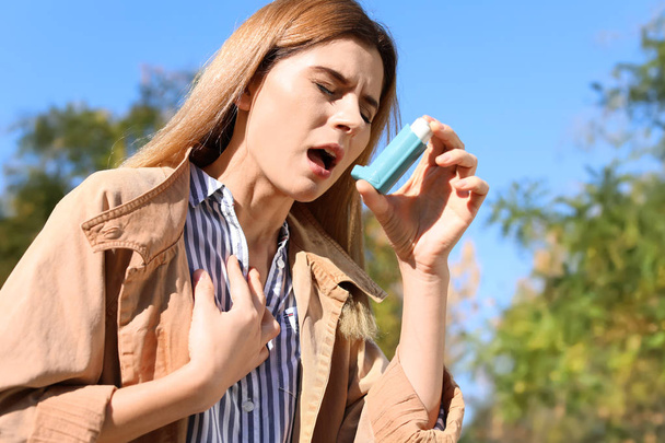 Woman using asthma inhaler outdoors. Space for text - Φωτογραφία, εικόνα