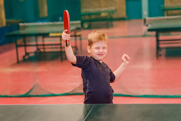 boy enjoys victory, the player who won table tennis indoors - Фото, изображение
