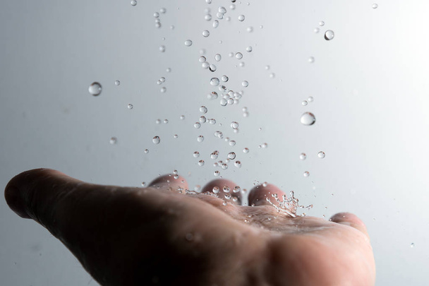 Human hand and splahing water. - Foto, Bild