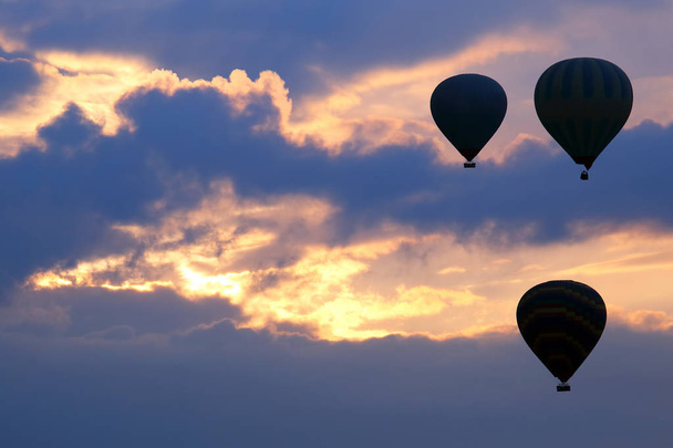 Wiele balonów pasażerskich latać na tle świtu w chmurach - Zdjęcie, obraz