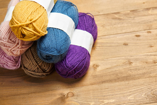hilos de lana de colores para tejer sobre fondo de madera
 - Foto, Imagen