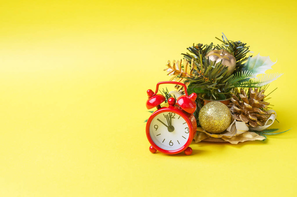 Christmas new year concept. Santa hat Christmas Tree cones gifts clock on yellow background - Φωτογραφία, εικόνα
