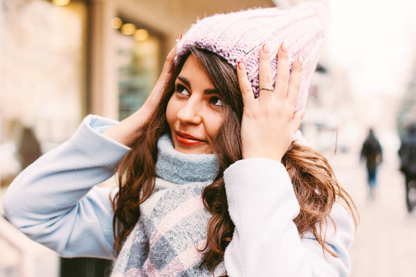 Νεαρή όμορφη γυναίκα στο παλτό και καπέλο του στα τέλη του φθινοπώρου ή το χειμώνα στο δρόμο απολαμβάνοντας τη ζωή της πόλης - Φωτογραφία, εικόνα