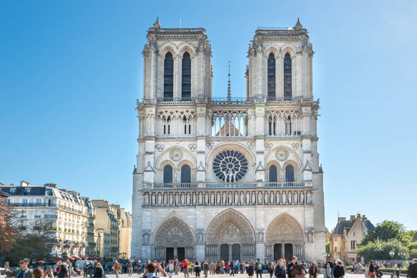 notre dame de paris - Menschen an der berühmten Kathedrale mit Sonne und blauem Himmel - Foto, Bild