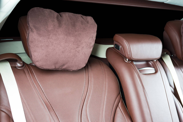 Задние пассажирские сиденья в современном роскошном автомобиле, белая перфорированная кожа со сшиванием
 - Фото, изображение