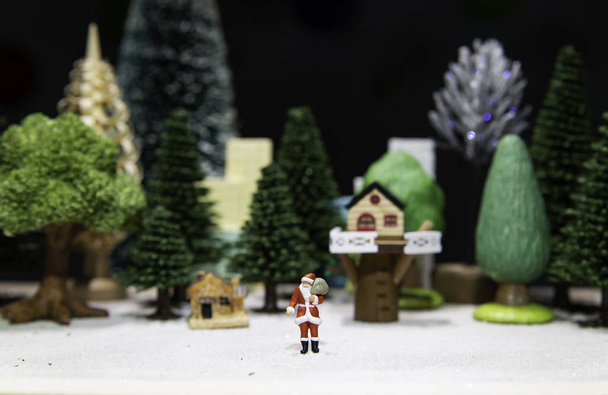 Le Père Noël s'éloigne des maisons dans les arbres de Noël
 - Photo, image