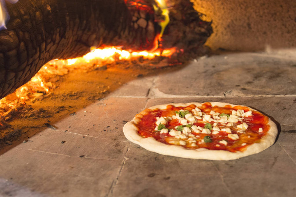 Pizza margherita cooking in stone oven - Photo, Image