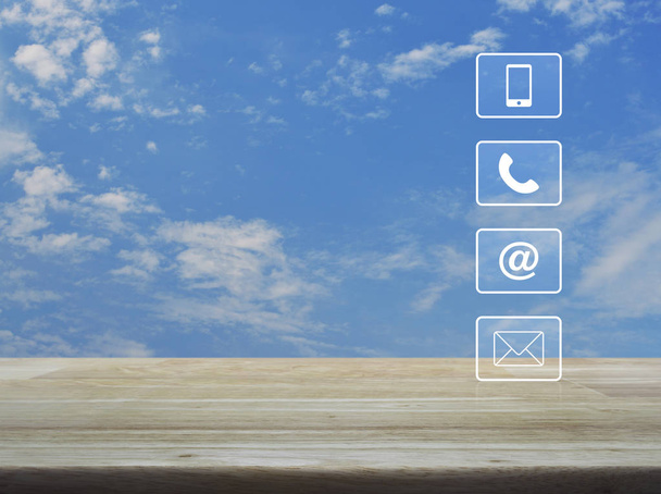 Τηλέφωνο, κινητό τηλέφωνο, διεύθυνση και email κουμπιά στο ξύλινο τραπέζι πάνω από το γαλάζιο του ουρανού με άσπρα σύννεφα, επιχειρηματικό concept εξυπηρέτησης και υποστήριξης πελατών - Φωτογραφία, εικόνα