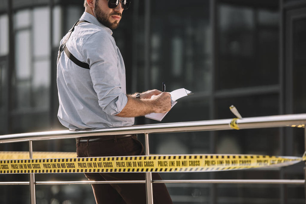  male detective in sunglasses making notes - Zdjęcie, obraz