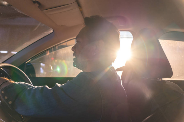 Gelukkig Aziatische man het besturen van een auto met sun ray op achtergrond - Foto, afbeelding