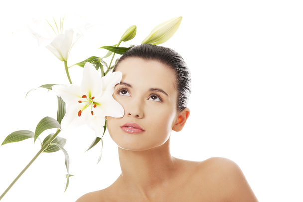 Fiatal nő a bőr egészségét és a liliom virág - Fotó, kép