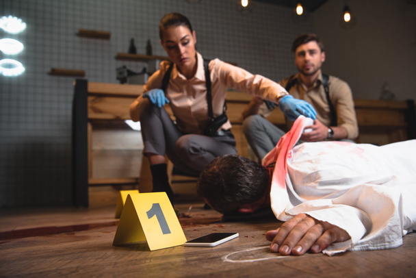 serious female and male detectives investigating dead body at crime scene  - 写真・画像