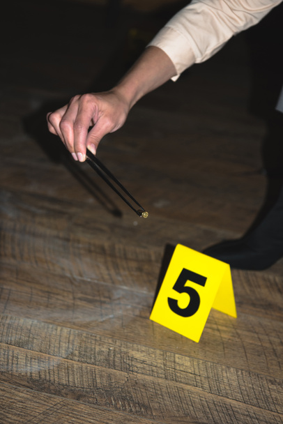 cropped view of hand examining evidence at crime scene - Photo, Image