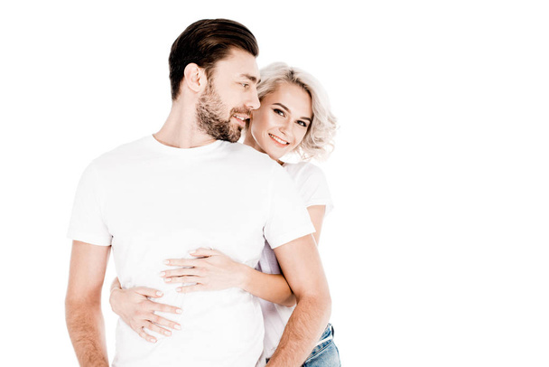 Beautiful smiling couple amorously hugging isolated on white - 写真・画像