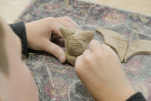 Uma criança molda um produto de argila em uma lição de modelagem. - Foto, Imagem