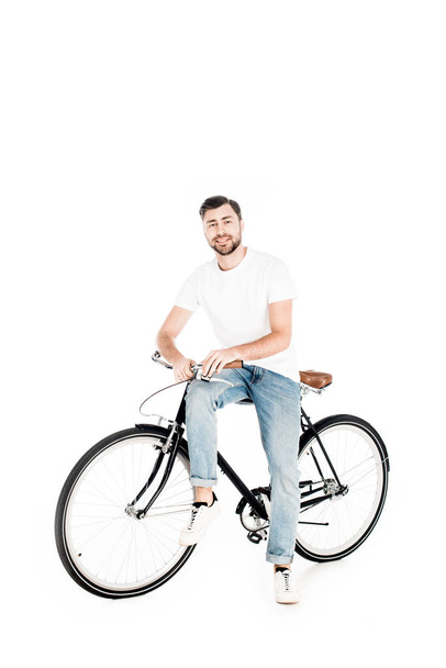 Handsome smiling man riding bicycle isolated on white - Foto, Imagem