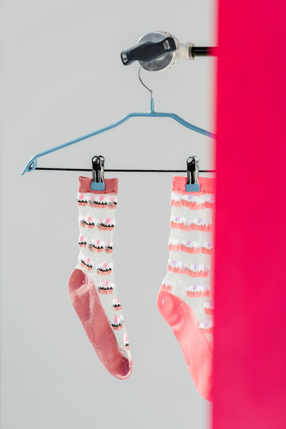 pair of pink socks with cake pattern on hanger - Foto, Bild