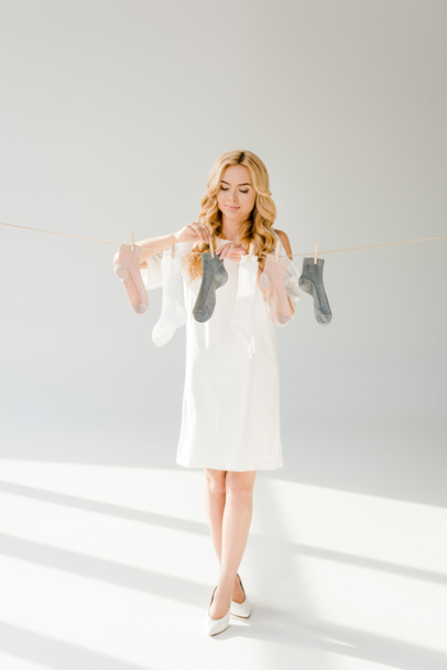 beautiful woman with socks hanging on clothesline  - Foto, Imagen
