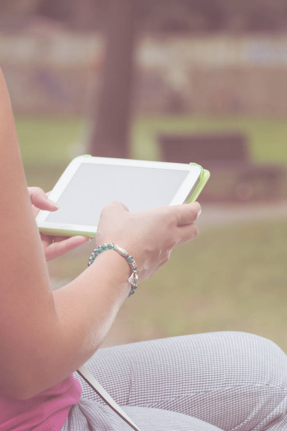 Detail of a woman using tablet in the park. - Photo, Image