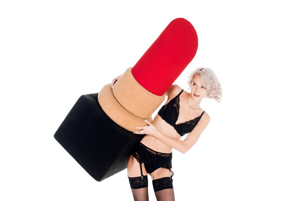 Fantástica jovem mulher adulta em lingerie segurando grande batom vermelho isolado no branco
 - Foto, Imagem