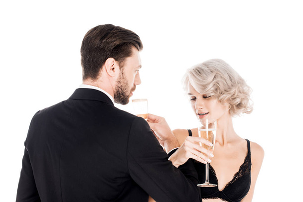 Attractive couple clinking glasses of champagne isolated on white - Fotó, kép