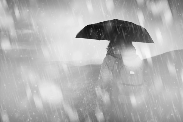 Ragazza con ombrello in una fredda giornata nevosa / piovosa
. - Foto, immagini