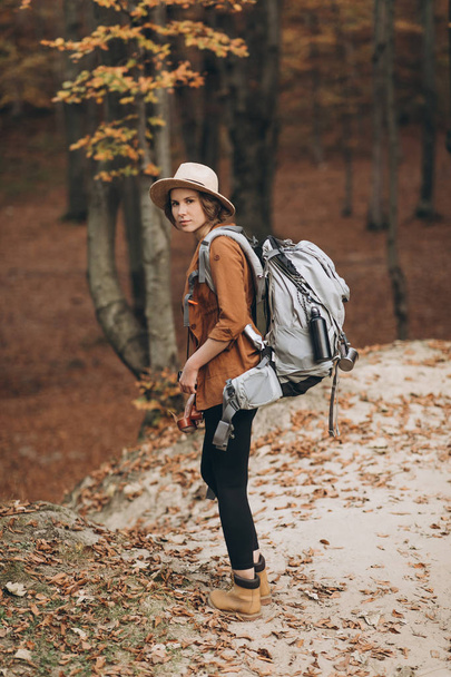 woman traveler with backpack looking at amazing forest, travel concept, space for text, atmospheric epic moment - Fotografie, Obrázek