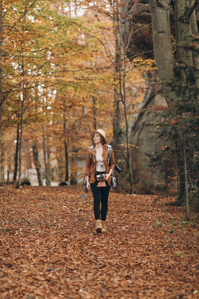 Beautiful young woman walking charming autumn forest - 写真・画像