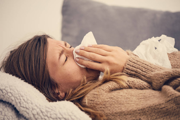 Хвора жінка з сезонними інфекціями, грипом, алергією лежить у ліжку
. - Фото, зображення