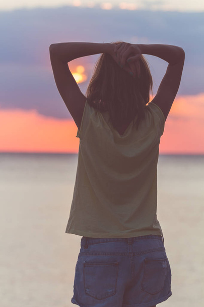 Silhouette di una ragazza con le mani in aria e paesaggi oceanici
. - Foto, immagini