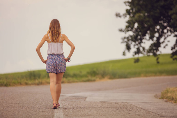 Lány séta egy üres külvárosában úton. - Fotó, kép