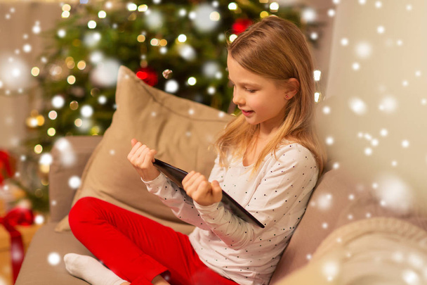 smiling girl with tablet pc at christmas home - Foto, imagen