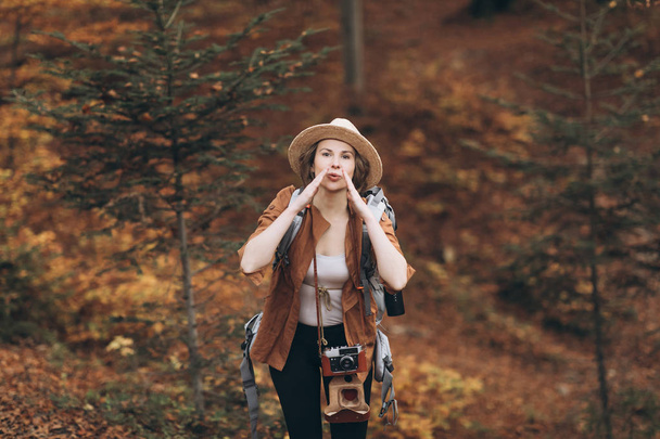 Beautiful girl in a hat in the autumn forest. The girl who travels - Фото, зображення