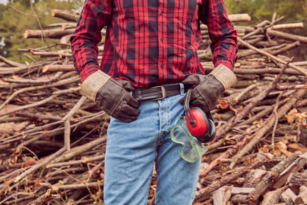 Holzfäller posiert vor einem geschnittenen Holzstapel. - Foto, Bild