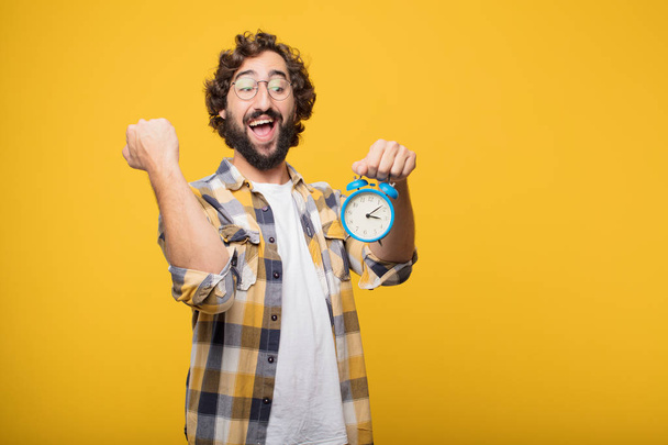 young crazy mad man in fool pose with a timer or alarm clock - Photo, image