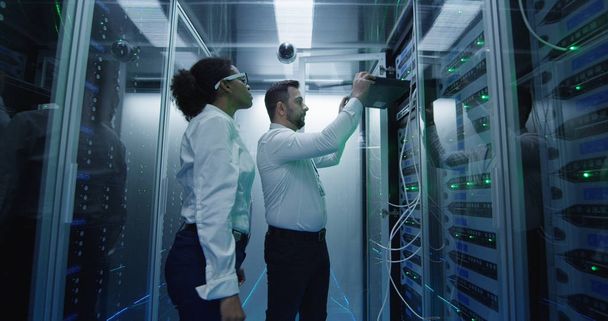 Due dipendenti che eseguono la manutenzione in un data center
 - Foto, immagini