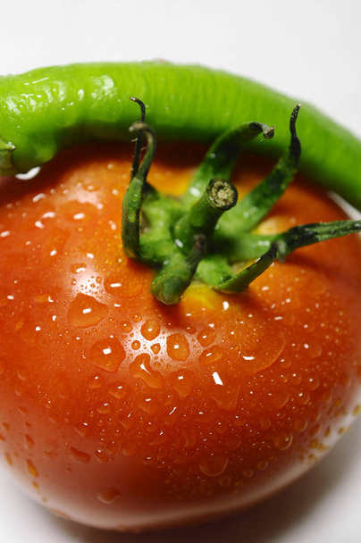 Viljelty näkymä vesipisaroita tomaatti ja vihreä paprika
 - Valokuva, kuva