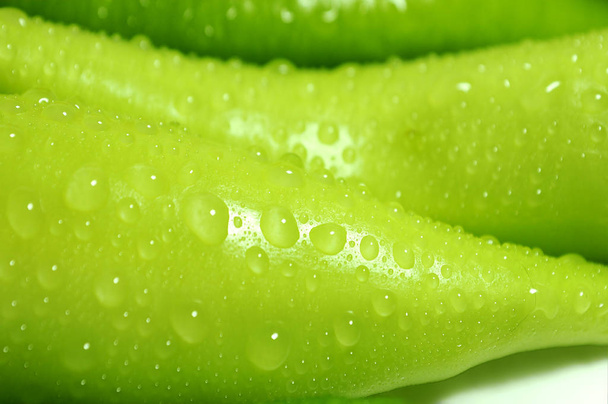 Bijgesneden uitzicht over water druppels op groene paprika 's - Foto, afbeelding