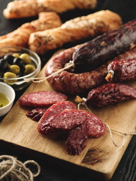 Salami sliced in rustic style. Salami sausage. Different sausages with cheese and olive. - Valokuva, kuva