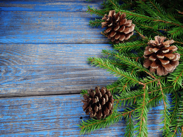 fondo de Navidad y decoración de conos con ramas de abeto en tablero de madera
 - Foto, Imagen